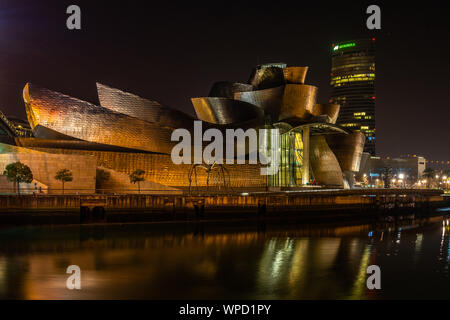 Scenic night cityscape of Bilbao Guggenheim Museum reflected in Nervion River, Bilbao, Basque Country, Spain
