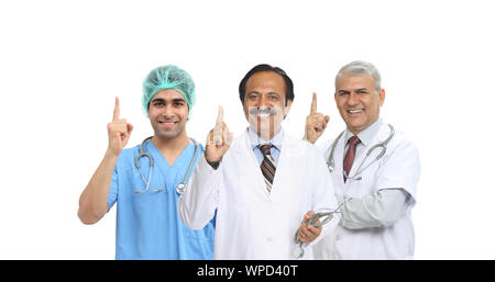 Portrait of confident group of doctors pointing upward Stock Photo