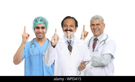 Portrait of confident group of doctors pointing upward Stock Photo