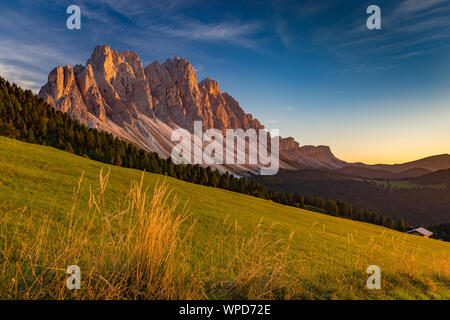 Sunset sunlight on the Odle massif, alpine grassland of the Funes Valley. Puez-Odle Natural Park. The Dolomites. Italian Alps. Europe. Stock Photo