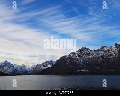 Expansive fjord in the Lofoten Islands surrounded with snowy mountains and blue sky. Norway. Stock Photo