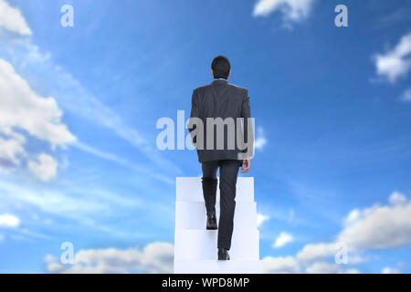 Rear view of a businessman walking up on staircase Stock Photo