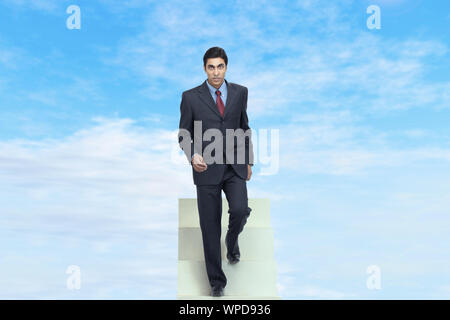 Businessman walking down staircase Stock Photo