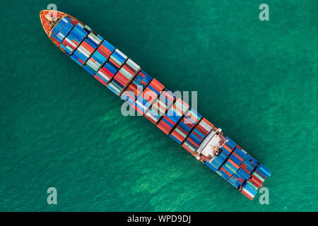 a cargo ship carrying multi-stack of containers in sea crossing international waters an aerial view, Singapore Stock Photo