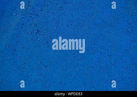 View texture blue synthetic waterproof clothing.Water drops on waterproof nylon. Rain drops on water resistant textile. Waterproof coating background Stock Photo