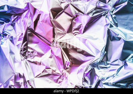 Crumpled colorful foil background. Abstract pattern with shadow. Neon pink and blue colors. Stock Photo