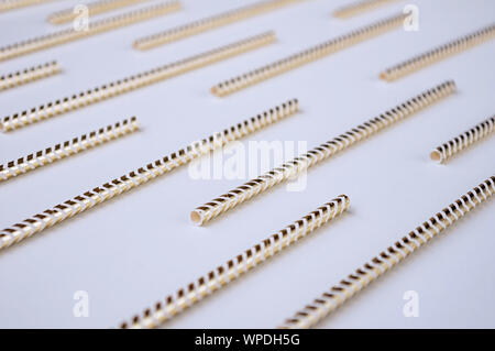 Golden cocktail straws on a white background. Holiday concept. Closeup. Stock Photo