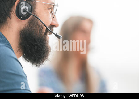 close up. smiling man in headset on blurred background Stock Photo