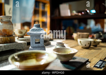 Taipei, Taiwan: Wooden table at traditional tea house in Jiufen, Taiwan. Laid with beautiful handmade, ceramic tea cups with blurry background Stock Photo