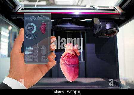 Hand with futuristic transparent smartphone. Application for printing human organs in a 3D printer. Stock Photo
