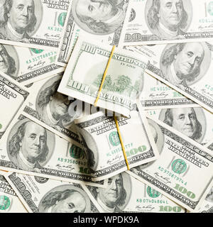 Stacks of one hundred dollars banknotes close-up on dollar background business concept top view with copy space. Stock Photo