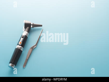 Otoscope with ear instrument on blue background. Stock Photo