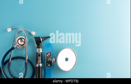 Otoscope with stethoscope and reflector mirror on blue background. Stock Photo