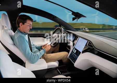Man resting while his car is driven by an autopilot. Self driving vehicle concept Stock Photo
