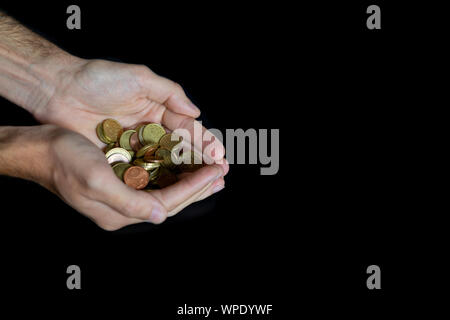 Man holding coins with both hands together. Euro money. Stock Photo