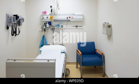 Empty hospital room with one bed, one chair and medical instruments on the wall. Health care concept. Medical room template Stock Photo