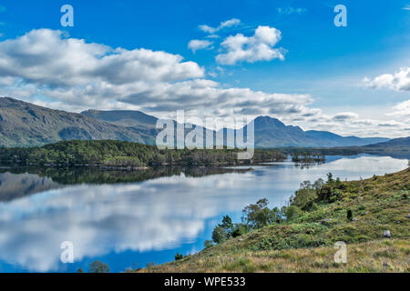 LOCH MAREE WESTER ROSS HIGHLANDS SCOTLAND LOOKING TOWARDS SLIOCH WITH PINE CLAD ISLANDS AND MIRROR CALM WATER Stock Photo