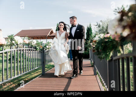 beautiful couple walking across the bridge in the Park. Stock Photo