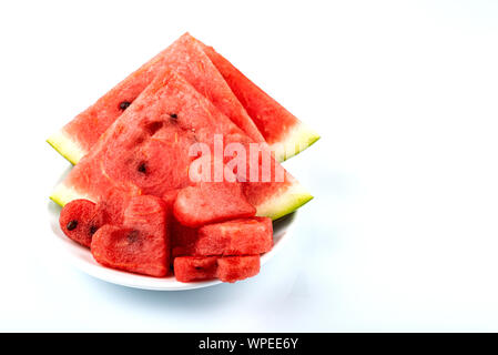Sliced watermelon in the shape of hearts and ordinary slices on a white background. Copy space. Stock Photo