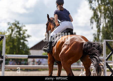 Young girl riding horse on equestrian sport contest. Show jumping image with copy space Stock Photo