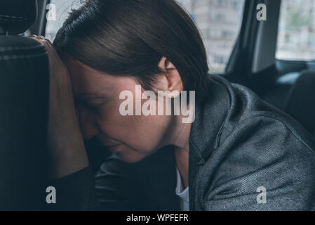 Tired businesswoman sleeping at car back seat, exhausted female executive fallen asleep in corporate limousine