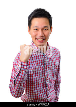 Happy excited young Asian man raising his fists doing yes gesture celebrating success Stock Photo
