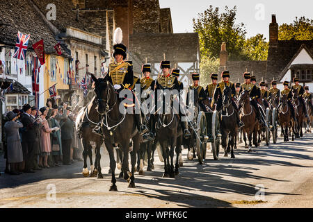 The Kings Troop Royal Horse Artillery during the shooting of a film version of smash TV hit Downton Abbey for cinema. The scene was shot in the High St the National Trust village of Lacock in Wiltshire with 80 horses and Guns and over 250 extras cheering and waving flags as the parade passed by. Stock Photo