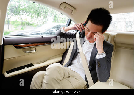 Stressed frustrated businessman talking on phone in the car Stock Photo