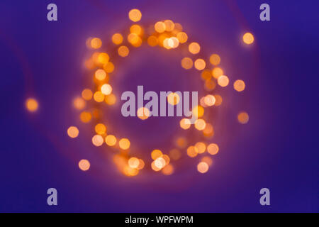 Blurred defocused magic fairy light glitter by Christmas lights on dark blue background, shallow DOF Stock Photo