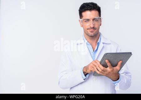 Young handsome man doctor with protective glasses using digital tablet Stock Photo