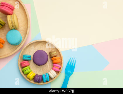 Set of different colorful macaroons Placed in a wooden tray, on many colors background. Sweet and tasty for cooking and restaurant menu. Top view, Spa Stock Photo