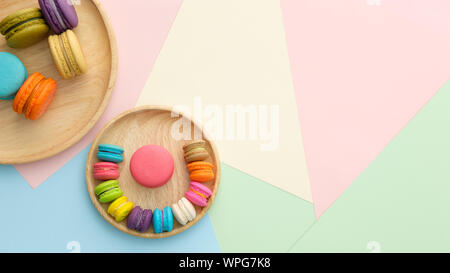 Set of different colorful macaroons Placed in a wooden tray, on many colors background. Sweet and tasty for cooking and restaurant menu. Top view, Spa Stock Photo