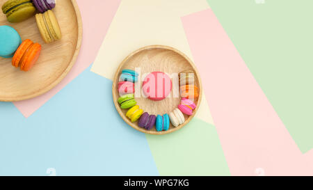 Set of different colorful macaroons Placed in a wooden tray, on many colors background. Sweet and tasty for cooking and restaurant menu. Top view, Spa Stock Photo