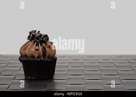 Tasty chocolate mini cupcakes on a vintage background, sweet dessert. Stock Photo