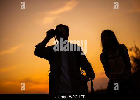 Happy couple is hiking in mountain in sunset. Stock Photo