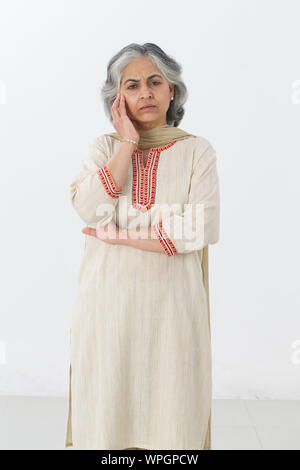 Senior woman thinking and looking sad Stock Photo