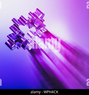 Christmas cutter as snowflake on neon pink and blue rays with shadow and duotone. Creative Xmas pattern. Square image. Stock Photo