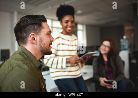 Portrait of a successful businessman with two female coworkers at background in the office Stock Photo