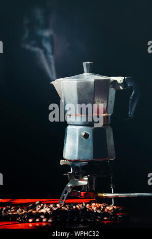 Moka pot old coffee maker and coffee beans on black background Stock Photo