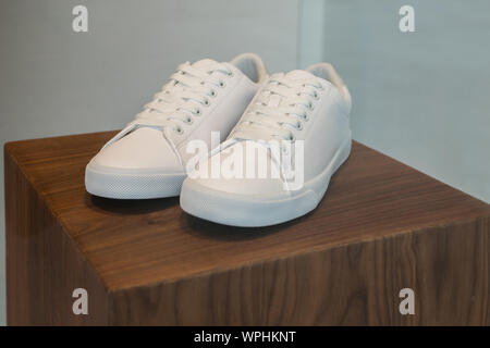 Close-up of the white shoes on the wooden display stand. Stock Photo