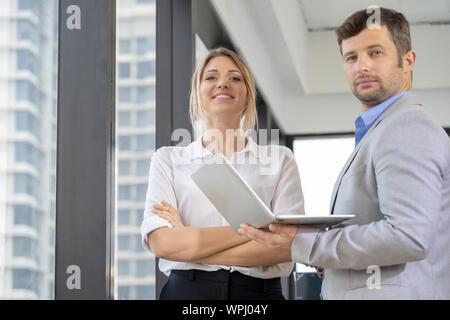 Couple of experienced business executives in working desk discussing on a laptop computer and desktop computer. Smile and thumb up. Stock Photo
