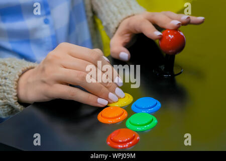 Gaming, technology, 80s concept - woman playing retro arcade machine game Stock Photo