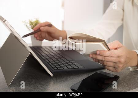 Hand holding a stylus pen And is working on the design of the notebook screen. Graphic designer is drawing pictures by a digital pen. Stock Photo