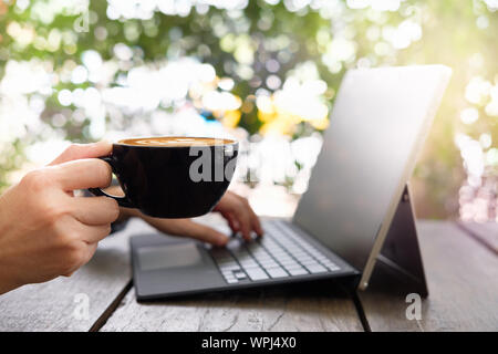 Young business woman working on laptop computer in the coffee shop cafe. Stock Photo