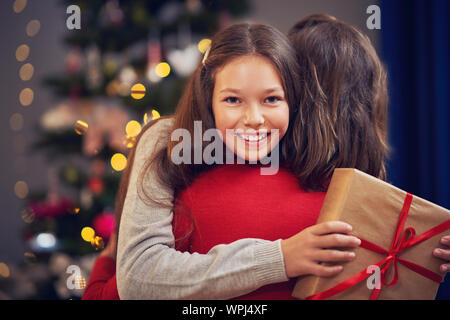 Daughter and father with present over Christmas tree Stock Photo