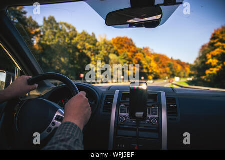 man hands on steering wheel riding by autumn speedway fall season Stock Photo