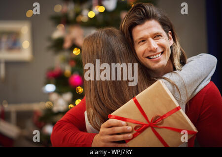 Daughter and father with present over Christmas tree Stock Photo
