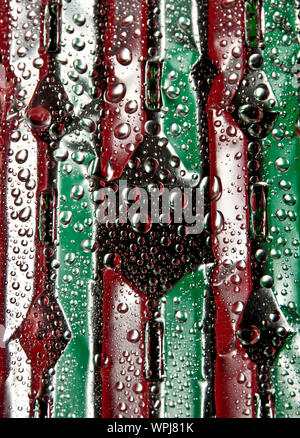 Fresh water drops on a green and red soft drink-like aluminum surface Stock Photo