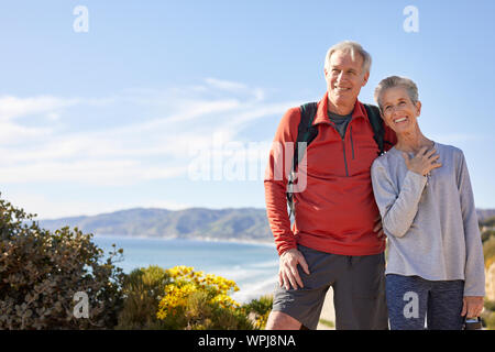 Cheerful senior couple standing against sky during sunny day Stock Photo