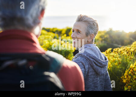 Smiling woman looking at man while standing outdoors Stock Photo